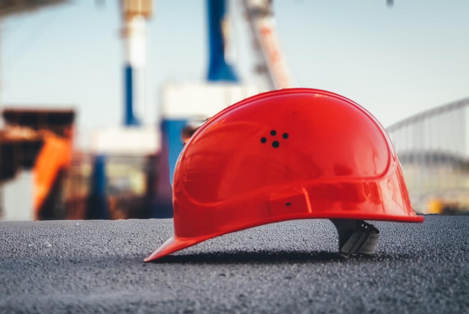 red hard hat on pavement\